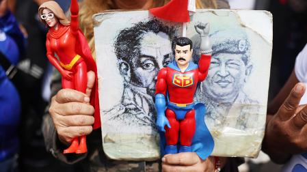 Un simpatizante de Maduro sostiene figuras del presidente de Venezuela, Nicolás Maduro, y de su esposa Cilia Flores, durante una manifestación de simpatizantes del oficialismo