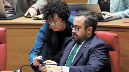 Javier Remírez e Inmaculada Jurío consultan el teléfono móvil del primero durante un pleno del Parlamento de la pasada legislatura