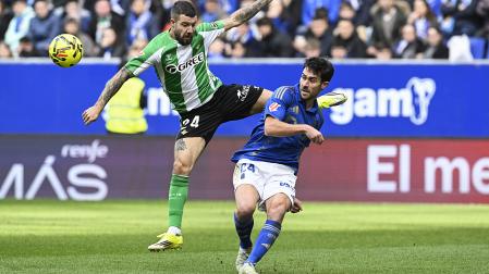 El defensa del Oviedo Lucas Ahijado despeja el balón ante la presión del bético Aitor Ruibal