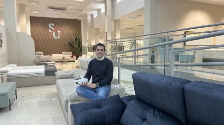 Sergio Urriza, en su tienda de muebles con las gafa de realidad virtual en la mano,