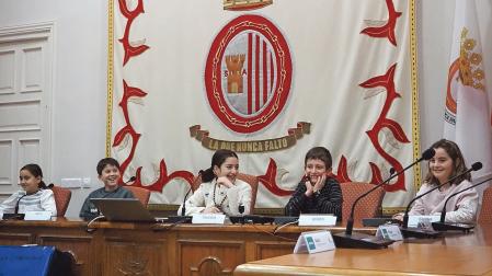 Gestos cómplices entre la corporación txiki de Sangüesa durante el pleno infantil de este sábado
