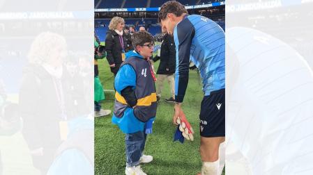 Momento en el que Álex Remiro regala sus guantes a Álvaro, un joven aficionado de la Real