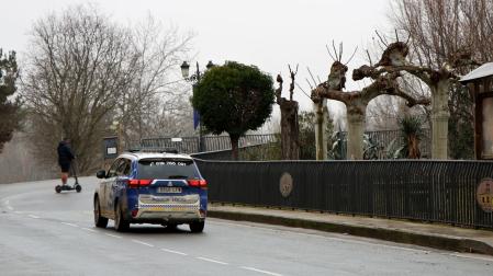 Un coche de Policía Local circula por la travesía de Peralta hacia el puente