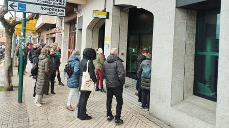 Varias personas esperan ante las puertas de la oficina de la Seguridad Social en Pamplona