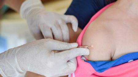 Un médico, vacunando a un niño.