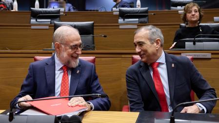 Los consejeros de Salud, Fernando Domínguez, y de Cohesión Territorial, Óscar Chivite, conversan en el hemiciclo del Parlamento