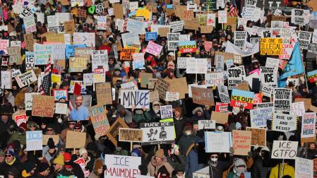 Miles de personas sostienen carteles durante una marcha contra el Servicio de Inmigración y Control de Aduanas de Estados Unidos (ICE) este viernes, en Mineápolis