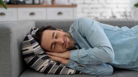 Imagen de archivo de un hombre echándose la siesta en el sofá