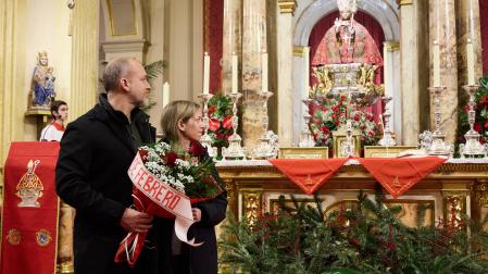 Husi y Miriam, padres de Marcos, con el ramo de rosas que depositaron junto a la imagen del santo