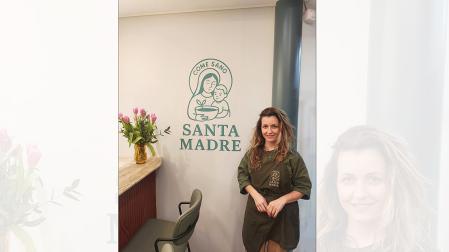 Mayra Alboccino, junto a logotipo de su establecimiento gastronómico saludable de la galería comercial Avenida.