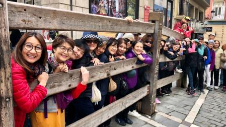 Un grupo de japoneses en el vallado fijo del encierro de la plaza del Ayuntamiento de Pamplona.