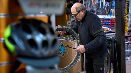 Rufino Hernaiz retira el pasador de la rueda trasera a la bicicleta de un cliente
