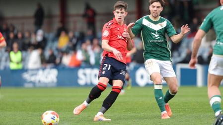 El lateral de Osasuna Promesas Raúl Chasco da un pase en presencia de Javi Ajenjo, del Cacereño