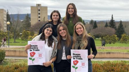 Voluntarias de la Universidad de Navarra posan en el campus con el cartel de 'Rosas contra la trata'.