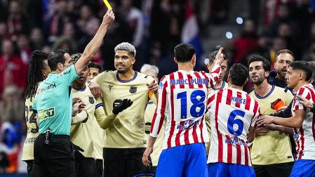El colegiado muestra una cartulina amarilla durante la ida de la semifinal de la Copa del Rey entre F.C. Barcelona y Atlético de Madrid