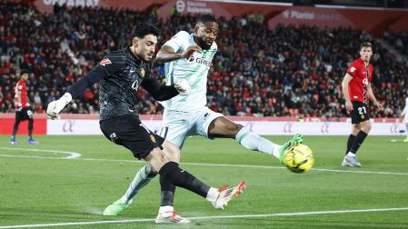 El delantero francés del Betis Cédric Bakambu presiona al portero del Mallorca Leo Román durante el partido