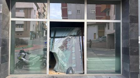Imagen del escaparate roto de un establecimiento contra el que chocó una motocicleta, cuyo conductor se dio a la fuga