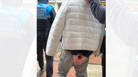 Agentes de la Policía Municipal conducen esposado a uno de los detenidos por intentar matar a un hombre en Pamplona