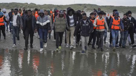 Un grupo de migrantes en Gravelinas (Francia) se adentran el pasado mes de agosto en el mar para subirse a un bote y cruzar el Canal de la Mancha hacia el Reino Unido