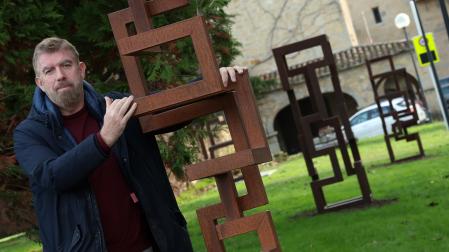 Ariel Elizondo posa con una de las esculturas de su muestra 'Densités' (Densidades') colocadas en la ruta del Camino de Santiago a su paso por el campus de la Universidad de Navarra.