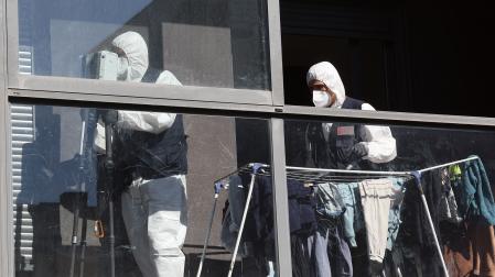 Efectivos de la  Policía Científica de Policía Foral, en el piso en el que se produjo el asesinato de una mujer a manos de su marido en Sarriguren