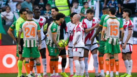 El delantero del Betis Ez Abde (c-i) conversa con el centrocampista del Rayo Vallecano Isi Palazón (c-d)