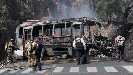 Bomberos e integrantes de la policía de Morelia trabajan en la zona donde fue incendiado un autobús por presuntos integrantes del crimen organizado este domingo,  tras el abatimiento de Nemesio Oseguera Cervantes, alias El Mencho, líder del Cártel Jalisco Nueva Generación (CJNG), en Morelia