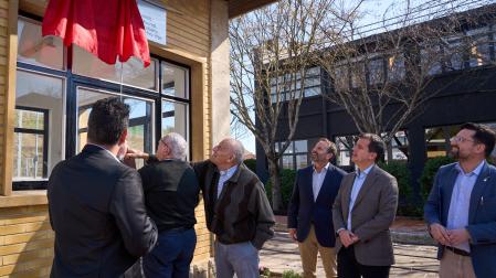 Alfredo Aguirre, de espaldas, y Alfonso Armendáriz, con la mano en el bolsillo, descubren la placa que colocó el Ayuntamiento del Valle de Elorz en la antigua entrada a Mocholí. Atentos el consejero Mikel Irujo y el director de fomento empresarial, Iñigo Arruti, y el alcalde del Valle de Elorz y el teniente de alcalde, Luis Maya y Mikel Navarro