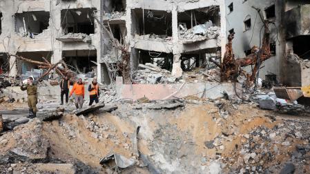 El personal de los servicios de emergencia inspecciona los daños en un edificio que fue alcanzado por un misil iraní en Tel Aviv, Israel