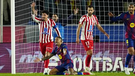El delantero del Barcelona Raphina reclama una falta ante José María Giménez, del Atlético