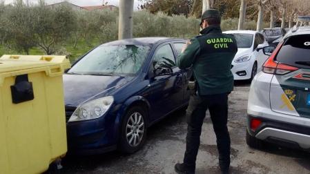 Un agente de la Guardia Civil fotografía uno de los vehículos dañados