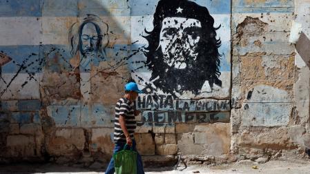 Una persona camina frente a un mural con la imagen de Ernesto 'Che' Guevara este jueves, en una calle de La Habana (Cuba)