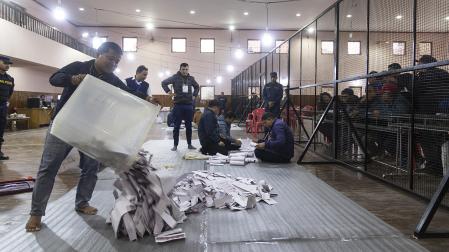 Varias personas proceden a realizar el recuento de votos en un colegio electoral de Katmandú
