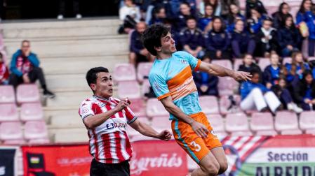Eloi Goñi, futbolista de la Mutilvera, salta ante Arman Lazkano, de la SD Logroñés