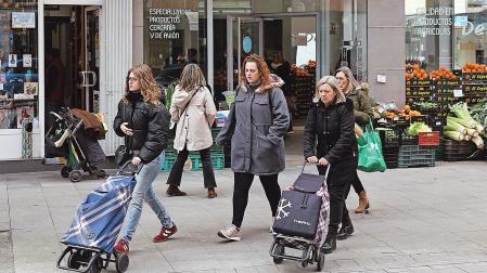 Dos mujeres con carritos de la compra en la calle Martín Azpilicueta del barrio de San Juan