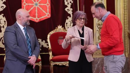 La consejera Rebeca Esnaola entrega a Eduardo Salvador Castiella el certificado que reconoce la donación realizada por su madre del fondo personal de Fernando Redón y, a la izquierda, el consejero José Luis Arasti
