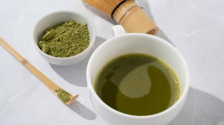 Una taza de té matcha y los utensilios para prepararlo