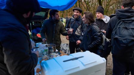 Protegidos por una lona, el grupo de ‘scout’ Doniantzu sirvió bebida y comida a los caminantes