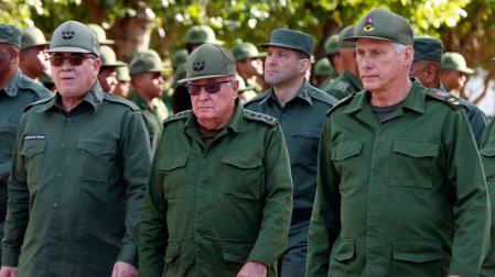 El nieto del expresidente Raúl Castro, Raúl Guillermo Rodríguez Castro (atrás), el presidente de Cuba, Miguel Diaz-Canel (d), el ministro del Interior, Lázaro Alberto Álvarez Casas (i) y el ministro de las Fuerzas Armadas de Cuba, Álvaro López Miera (c), asisten a un acto en La Habana