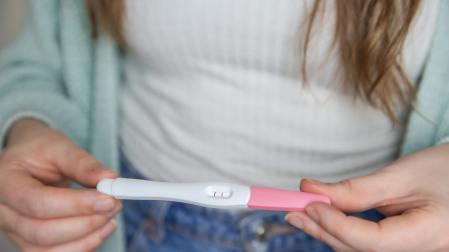 Una mujer sostiene un test de embarazo