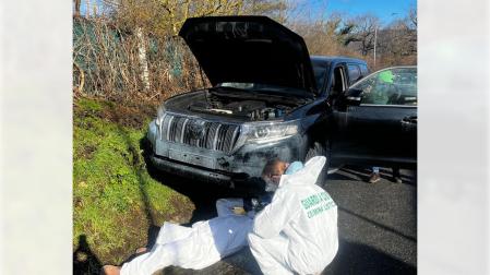 Dos guardias civiles examinan uno de los coches robados