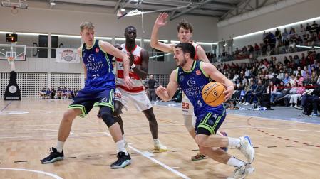 Alex Calvo con el balón frente a un rival de Logrobasket.