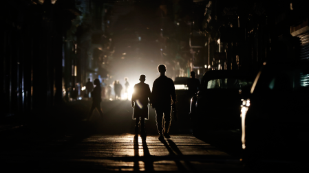 Personas caminan por una calle sin electricidad este sábado, en La Habana (Cuba)
