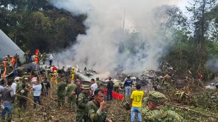 Integrantes de las Fuerzas Militares de Colombia, rescatistas y voluntarios realizan labores de rescate este lunes, en Puerto Leguizamo (Colombia), en el lugar del avión accidentado