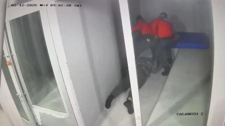 Un fotograma de la grabación de calabozos: dos de los agentes acusados (a la izquierda el que propinó los golpes), tras tirar al detenido al suelo para engrilletarlo