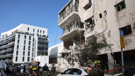 Equipos de emergencia israelíes trabajan en el lugar de un ataque con misiles iraníes en una zona residencial de Tel Aviv