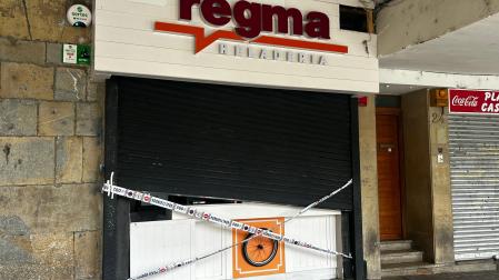 Precinto policial en el local, con los daños en la persiana