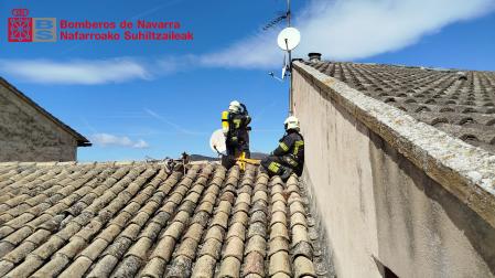 Dos bomberos trabajando en el tejado de la vivienda afectada por un incendio en San Martín de Unx