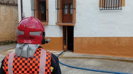 Imagen de un bombero junto a la vivienda afectada