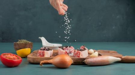 Condimenta con sal pedazos de carne